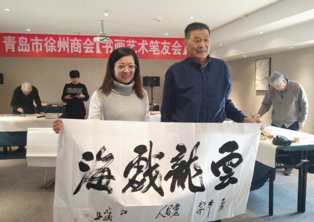 吴碧林先生(右)和蔡可忠先生(左)展示吴老先生的作品《春到华夏万里香