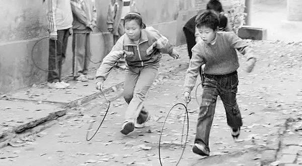 皮筋其实是旧自行车胎剪成的胶皮圈,三五个人一起玩,唱着"马兰花"的